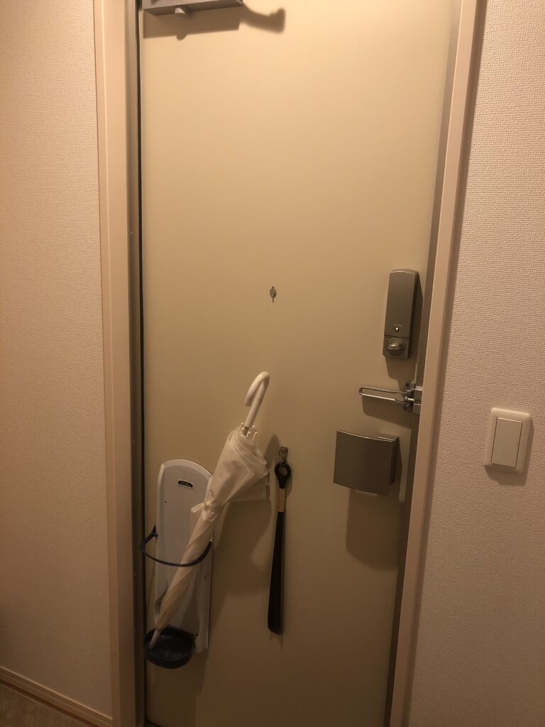 玄関ドアにマグネット式傘置きを置いている写真